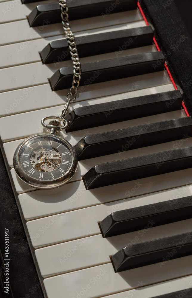 Antique pocket watch or Retro pocket watch on Piano keys background.