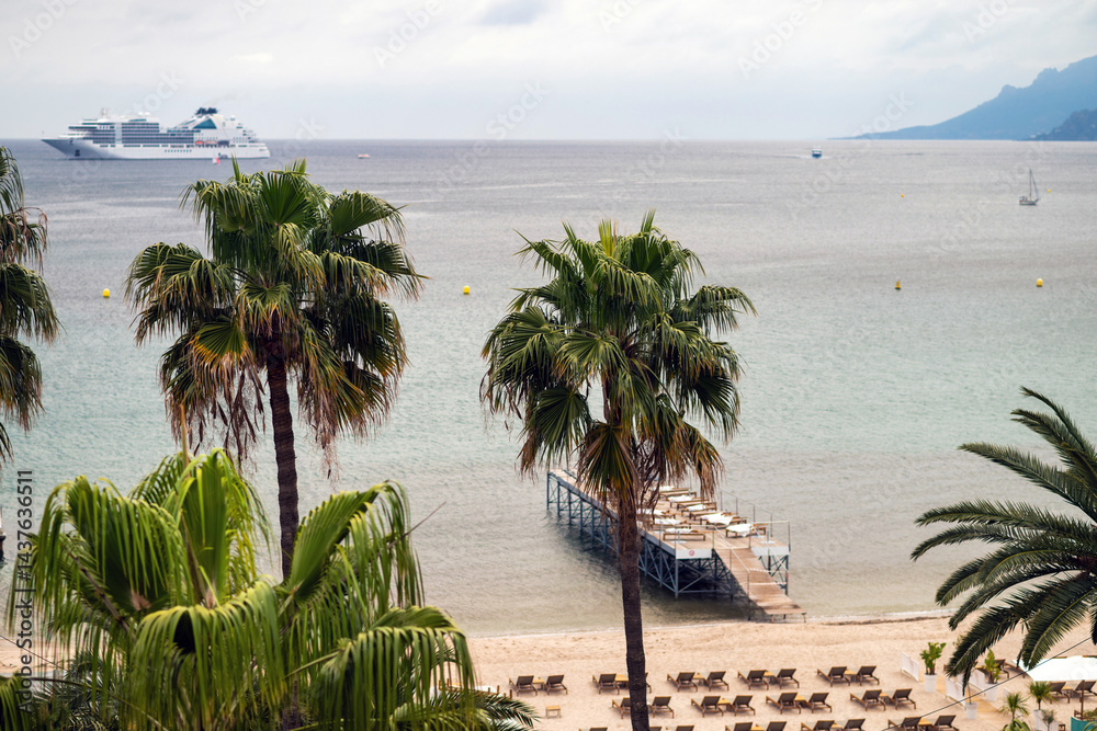 French Riviera beach view with palm trees