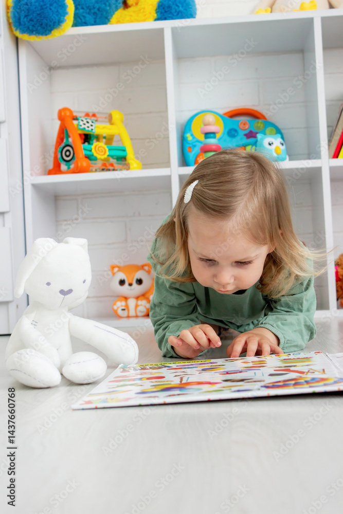 Fototapeta premium little girl reading a book. development