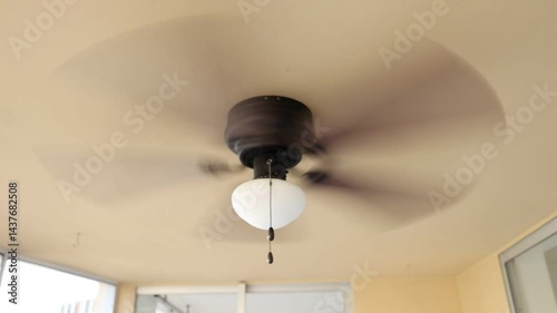 Ceiling fan fast spinning brown fin white lantern