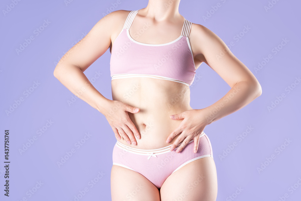 Slim woman in pink underwear on purple background, body care concept Slim woman in pink underwear on purple background, body care concept