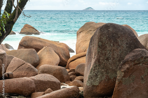 Obraz na płótnie Massive granite boulders on a tropical beach of Praslin, Seychelles, with turquoise sea waves w salonie