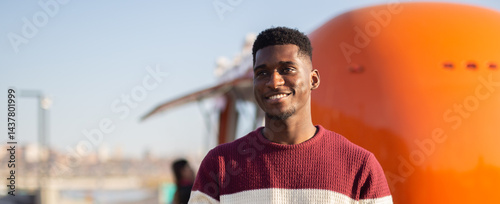 Obraz na płótnie African american man smiles on a sunny city day. Concept of happiness, relaxation, travel and urban lifestyle w salonie