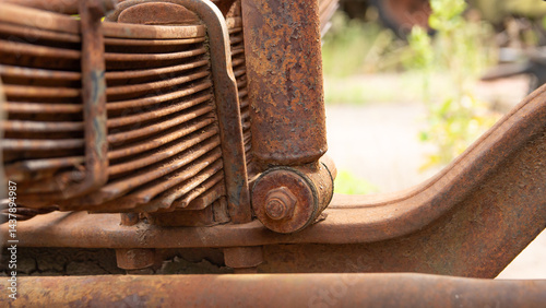 Schilderij op canvas Close-up of heavily rusted leaf springs and a shock absorber, components of a vehicle's suspension system
