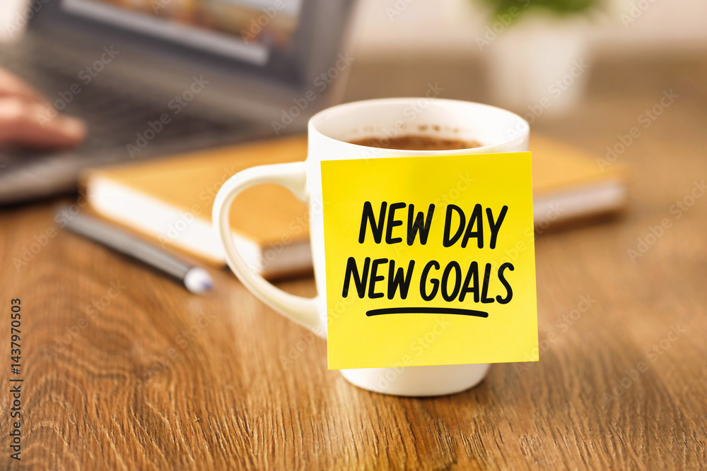 Coffee cup with yellow sticky note showing new day new goals message on wooden desk workspace motivation inspiration business planning idea work concept