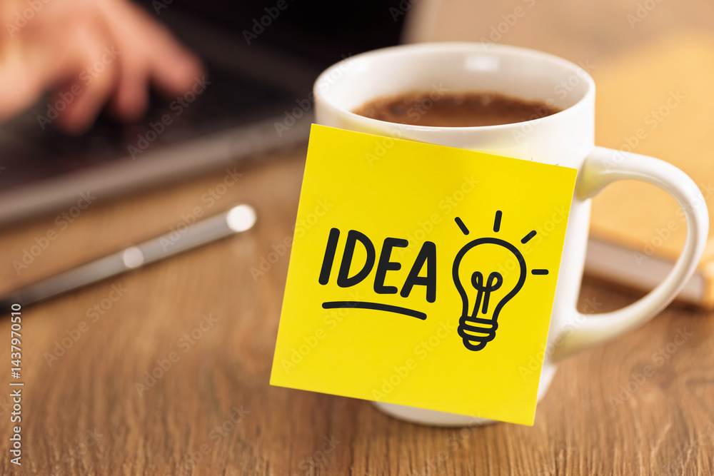 Coffee cup with yellow sticky note showing idea and lightbulb symbol on wooden desk workplace creativity productivity business startup goal planning innovation motivation