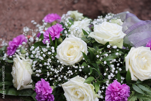 Фотография Flower arrangement of white roses and pink carnations at the grave