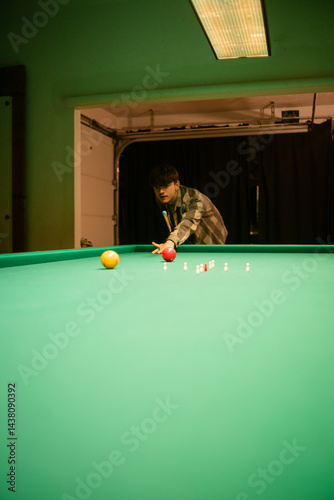 Player focuses while shooting on green pool table