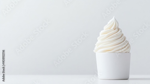 A swirled soft serve ice cream in a white cup on a minimalist background, close-up shot with soft lighting, and clean and simple composition.