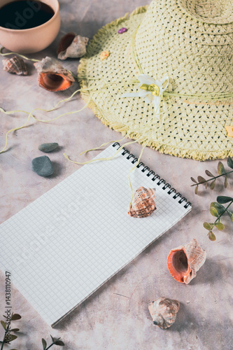 Obraz na płótnie Notebook, beach hat, shells and stones on the table vertical view w salonie