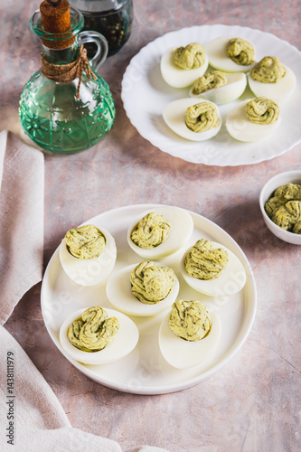 Avocado deviled eggs for appetizer on plate on table vertical view