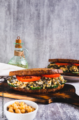 Obraz na płótnie Vegetarian sandwich with seaweed, chickpeas, cucumber and tomato on grain bread vertical view w salonie