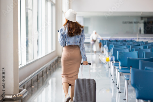 Obraz na płótnie Back view woman hand touching baggage. Stewardess or air hostess carrying suitcase modern airport terminal. flight attendant w salonie