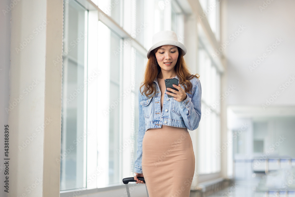 Happy Female Travelling use smartphone. Happy asian woman passenger traveler waiting for departure with suitcase at modern airport terminal