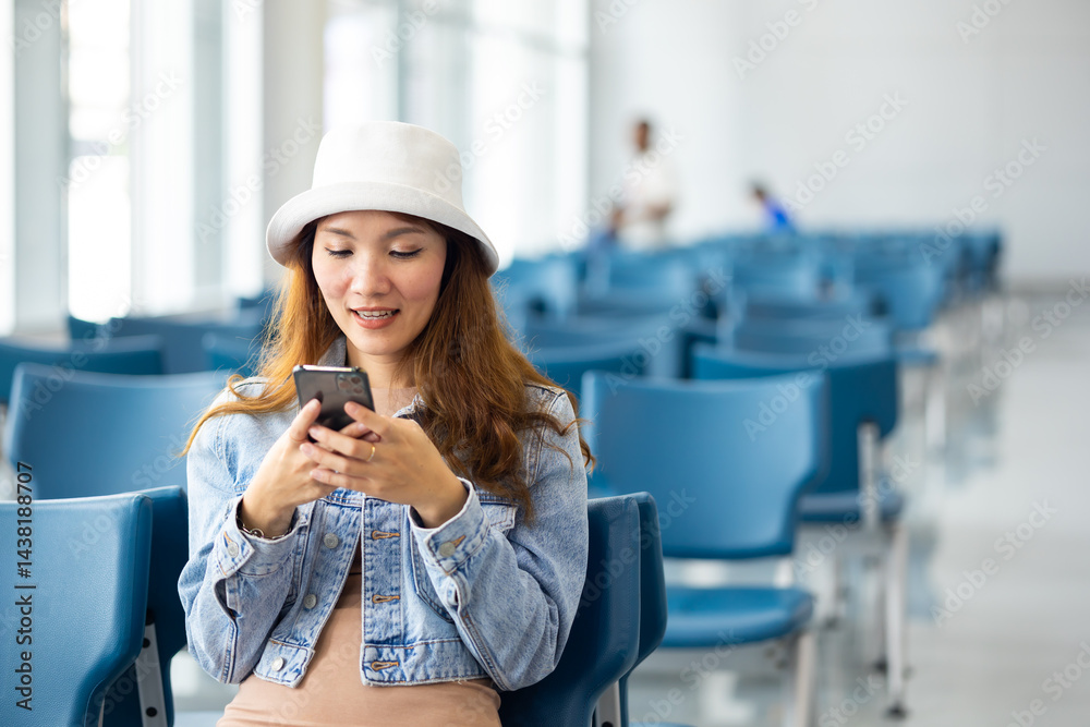 Happy Asian Woman waiting for flight at airport lounge. Happy asian woman passenger traveler waiting for departure with suitcase at modern airport terminal