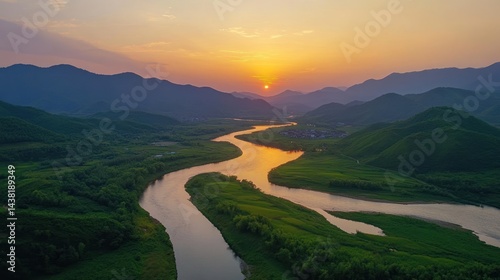 Sunset Serenity: A Panoramic View of a River Winding Through Verdant Mountains