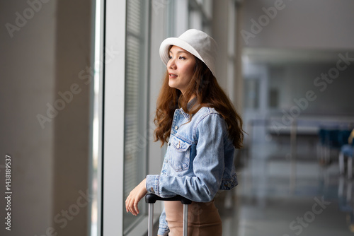 Obraz na płótnie Portrait Happy Asian Female traveler passenger with luggage. Happy Asian beautiful woman passenger traveler waiting for departure with suitcase at modern airport terminal w salonie