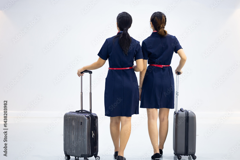 Back view two Cabin crew or air hostess in airport. Cabin crew, air hostess working in airplane. Service mind. Asian stewardess with suitcase at modern airport terminal. flight attendant