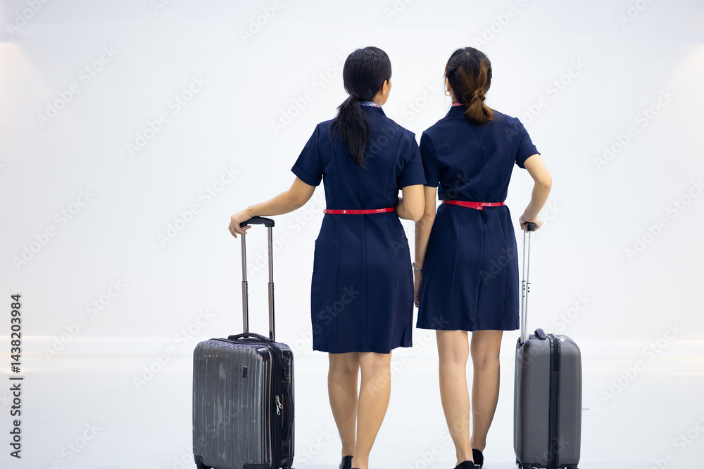 Back view two Cabin crew or air hostess in airport. Cabin crew, air hostess working in airplane. Service mind. Asian stewardess with suitcase at modern airport terminal. flight attendant