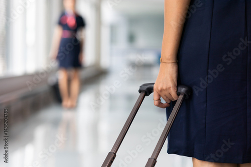 Obraz na płótnie Closeup hand woman Walking in airport. Cabin crew, air hostess working in airplane. Service mind. Asian stewardess with suitcase at modern airport terminal. flight attendant w salonie