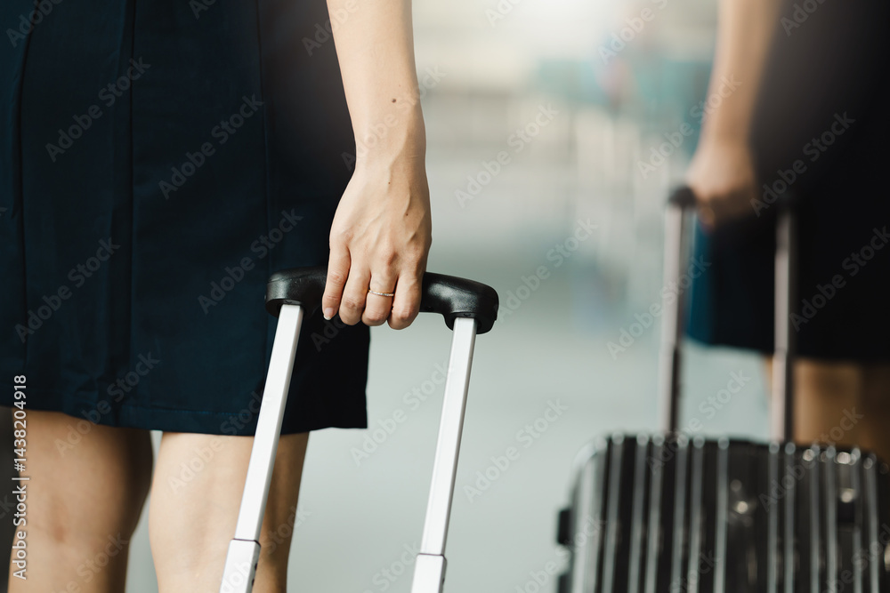Closeup hand woman Walking in airport. Cabin crew, air hostess working in airplane. Service mind. Asian stewardess with suitcase at modern airport terminal. flight attendant