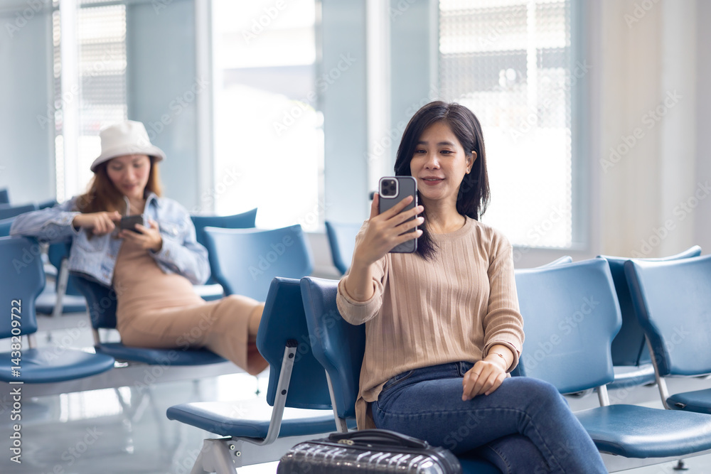 Happy Asian Woman waiting for flight at airport lounge. Happy asian woman passenger traveler waiting for departure with suitcase at modern airport terminal