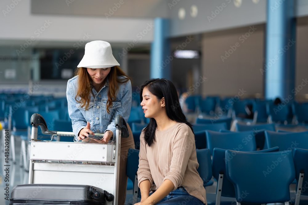 Internet Online Check flight schedule on smartphone. arrival and departure board. Two Asian woman use smartphone cheking flight for travel in long weekend