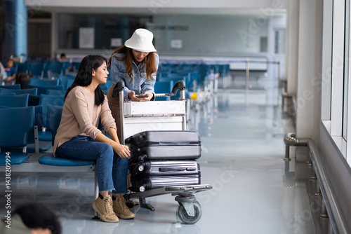 Obraz na płótnie Internet Online Check flight schedule on smartphone. arrival and departure board. Two Asian woman use smartphone cheking flight for travel in long weekend w salonie