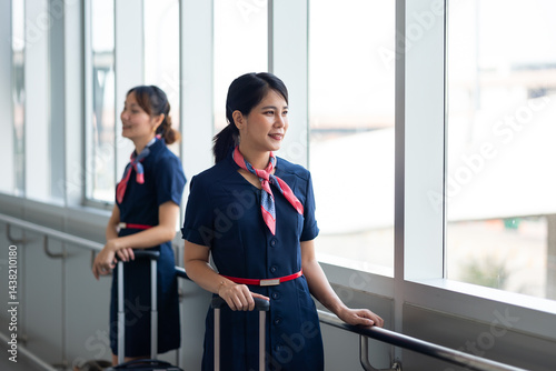 Obraz na płótnie Portrait female Cabin crew or air hostess in airport. Cabin crew, air hostess working in airplane. Service mind. Asian stewardess with suitcase at modern airport terminal. flight attendant w salonie