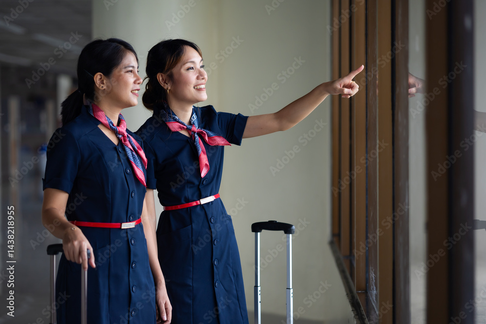 Portrait two Cabin crew or air hostess in airport. Cabin crew, air hostess working in airplane. Service mind. Asian stewardess with suitcase at modern airport terminal. flight attendant