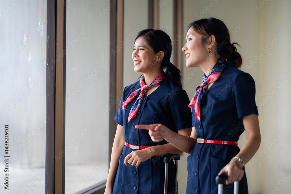 Portrait two Cabin crew or air hostess in airport. Cabin crew, air hostess working in airplane. Service mind. Asian stewardess with suitcase at modern airport terminal. flight attendant