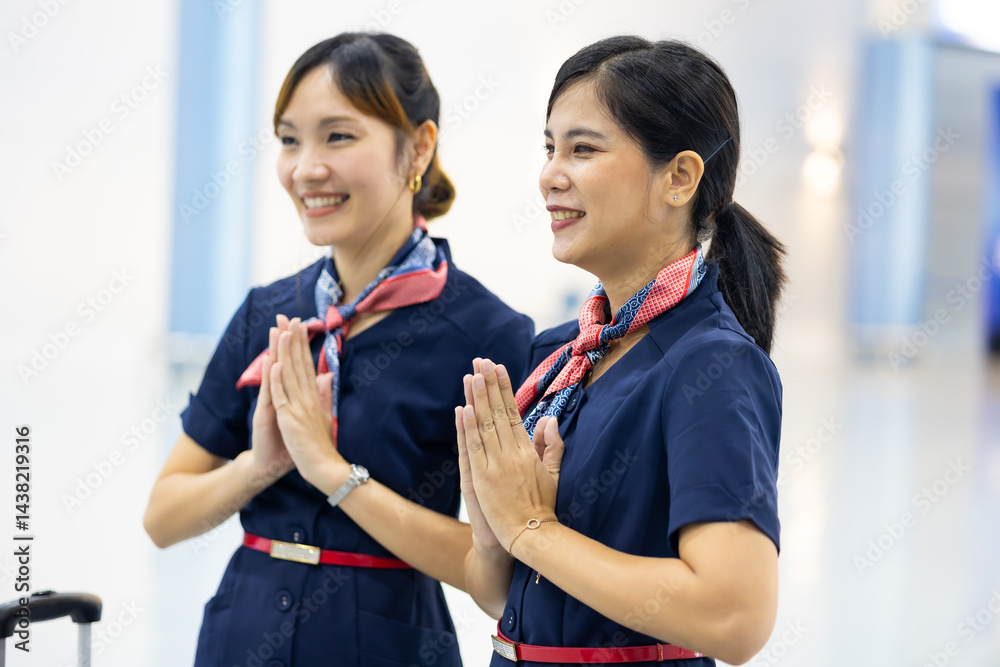 Portrait two woman friends sawasdee thai hello in airport. Cabin crew, air hostess working in airplane. Service mind. Asian stewardess with suitcase at modern airport terminal. flight attendant