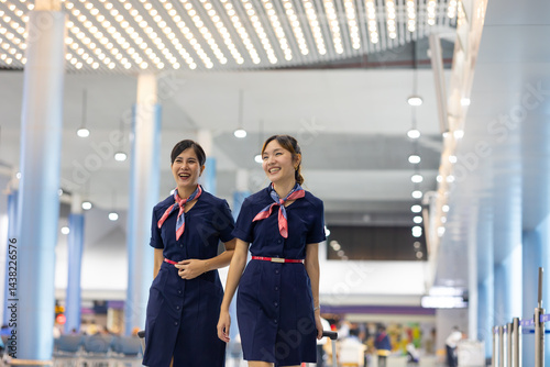 Walking in airport. Cabin crew, air hostess working in airplane. Service mind. Asian stewardess with suitcase at modern airport terminal. flight attendant