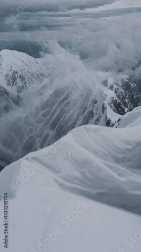 Vertical shot - snowy mountains - storm snow drone flyover