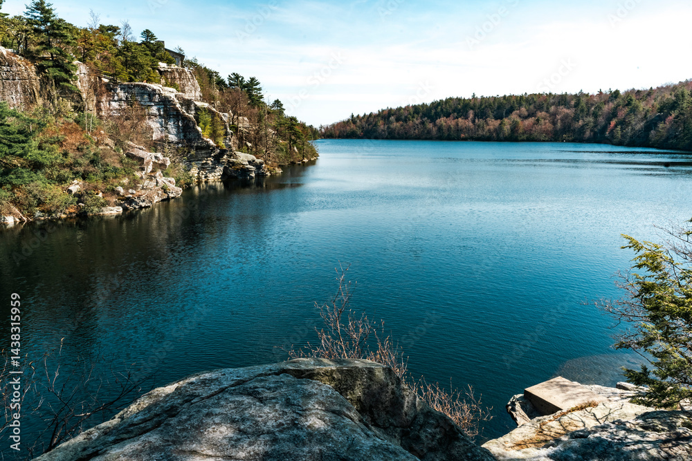 Kerhonkson, NY - US - Apr 23, 2025 Lake Awosting glistens under a clear sky, bordered by rugged cliffs and forested hillsides in Minnewaska State Park—a serene gem perfect for nature lovers.
