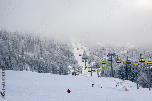 Fototapeta Naklejka Na Ścianę i Meble -  Chairlift through foggy forest
