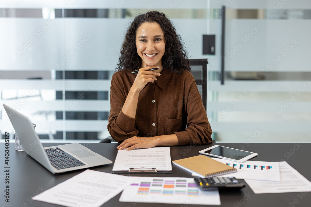 Portrait of a successful businesswoman, financier, accountant. Company employee looking at the camera, working with documents, papers and reports.