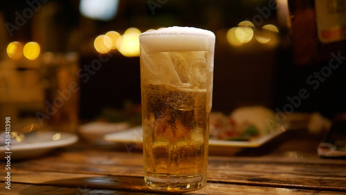 Obraz na płótnie Beer glass on the table alcoholic beverage social party activity and relaxation at night golden drink w salonie