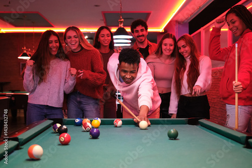 Obraz na płótnie Group of friends enjoying a night out, playing pool and having fun in a vibrant bar w salonie