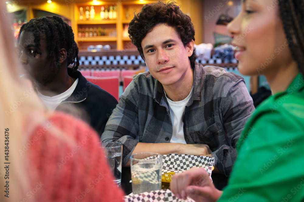 Group of diverse friends enjoying a meal together in a casual diner setting, engaging in conversation and creating memories