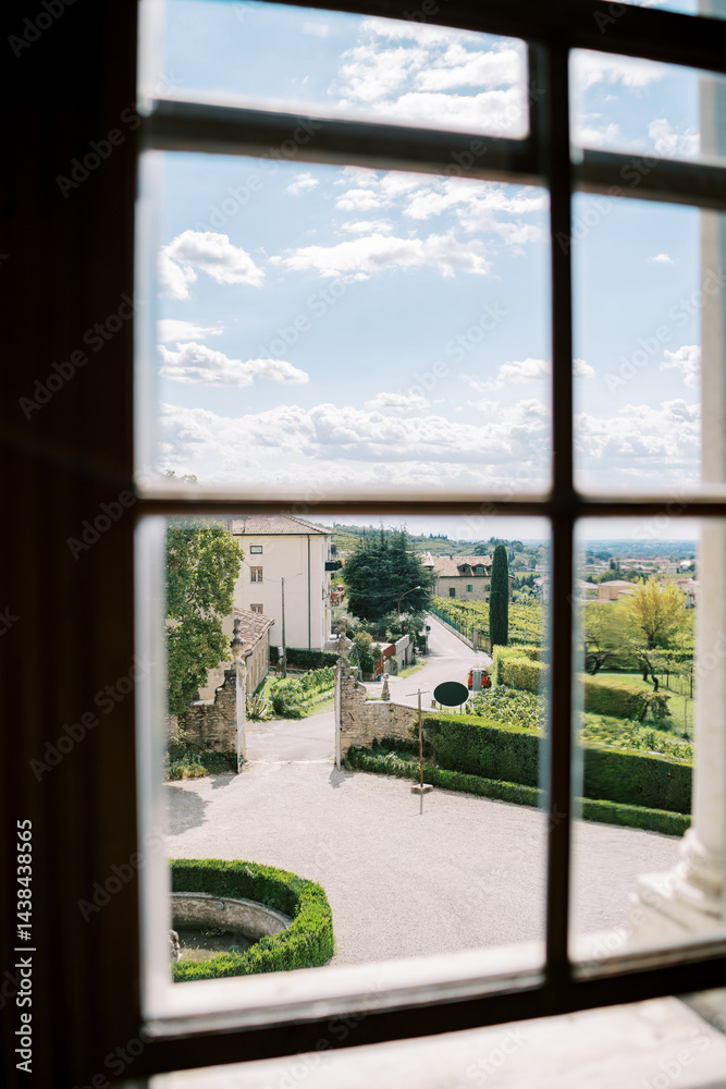 Fototapeta premium View from the window of the road and trimmed bushes in the garden near the house