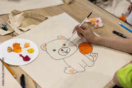 Creative Tote Bag Painting Workshop: Drawing Teddy Bear with Acrylic Paints on Text. Art therapy for children in crisis: painting on fabric bags as emotional support. Eco-friendly kids' craft. 