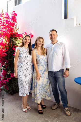 A cute teenager and her parents in fancy clothes are smiling and posing