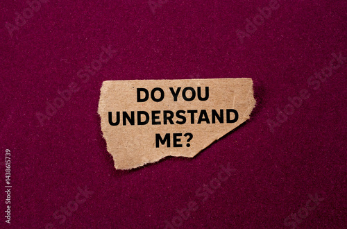 Do you understand me message written on ripped torn brown paper piece on purple background. Conceptual do you understand me symbol. Copy space.