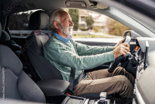 Side view of senior driver in smart causal driving his car.