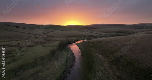Aerial shot of a sunrise over river in the valley