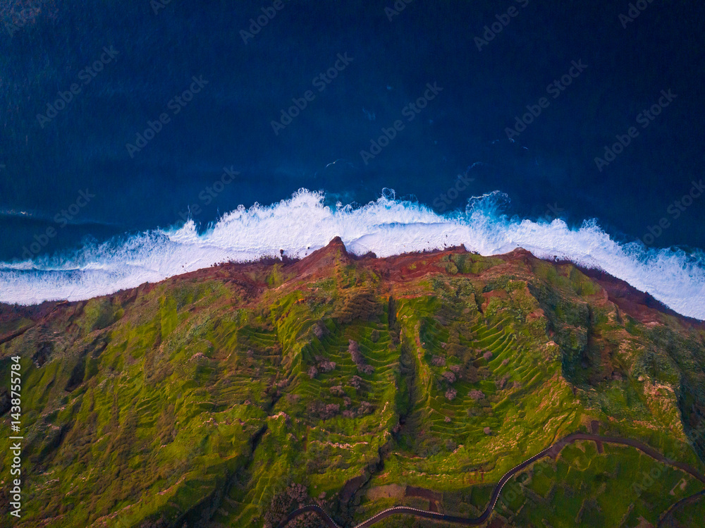 Breathtaking view of the vibrant green cliffs and crashing waves along a pristine coastline at dawn