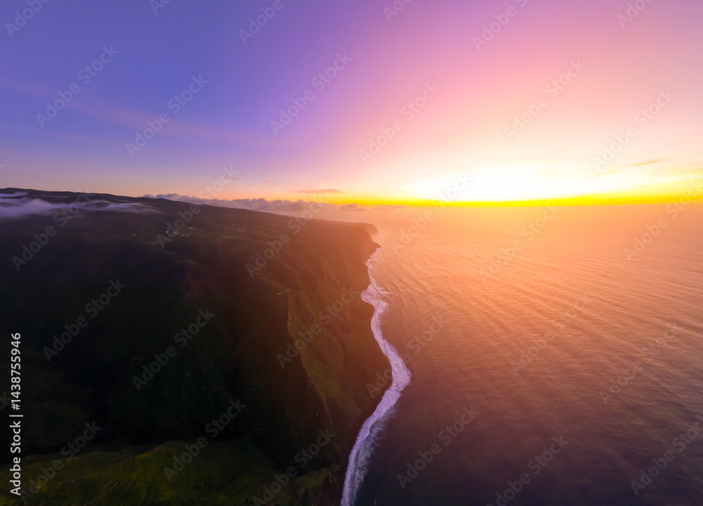 Vibrant sunset illuminates the rugged coastline and vast ocean waters at twilight, showcasing natures breathtaking beauty in a tranquil setting
