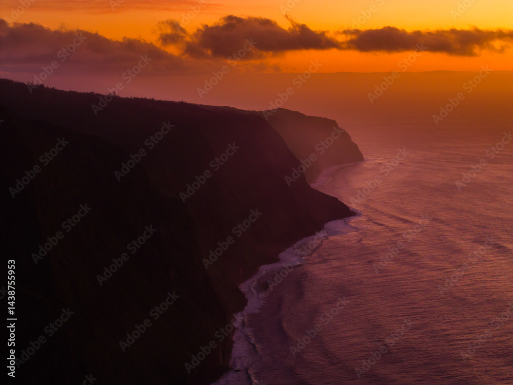 Captivating sunset over rugged cliffs by the ocean with vibrant colors reflecting on tranquil waters