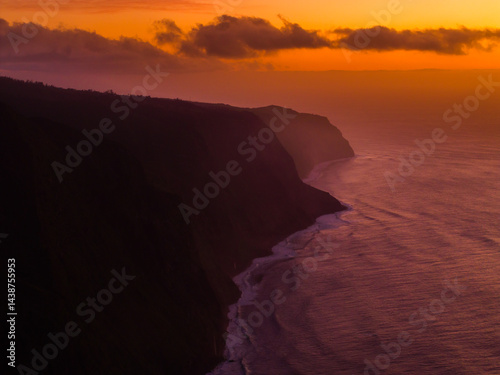 Obraz na płótnie Captivating sunset over rugged cliffs by the ocean with vibrant colors reflecting on tranquil waters w salonie